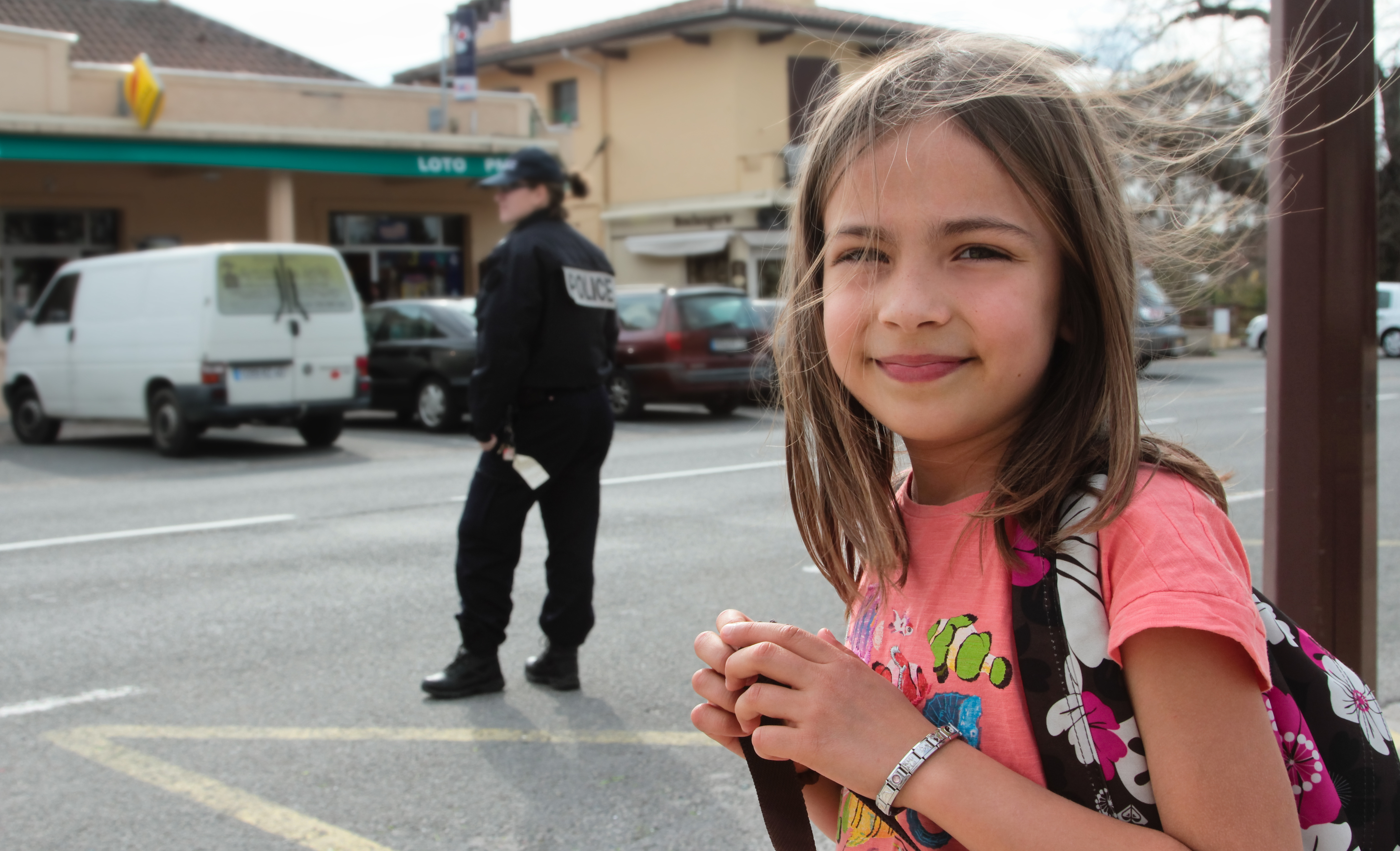 Prevention and Safety Personified: Smiling Girl and Blurred Policeman Symbolize the Mayor’s Mission