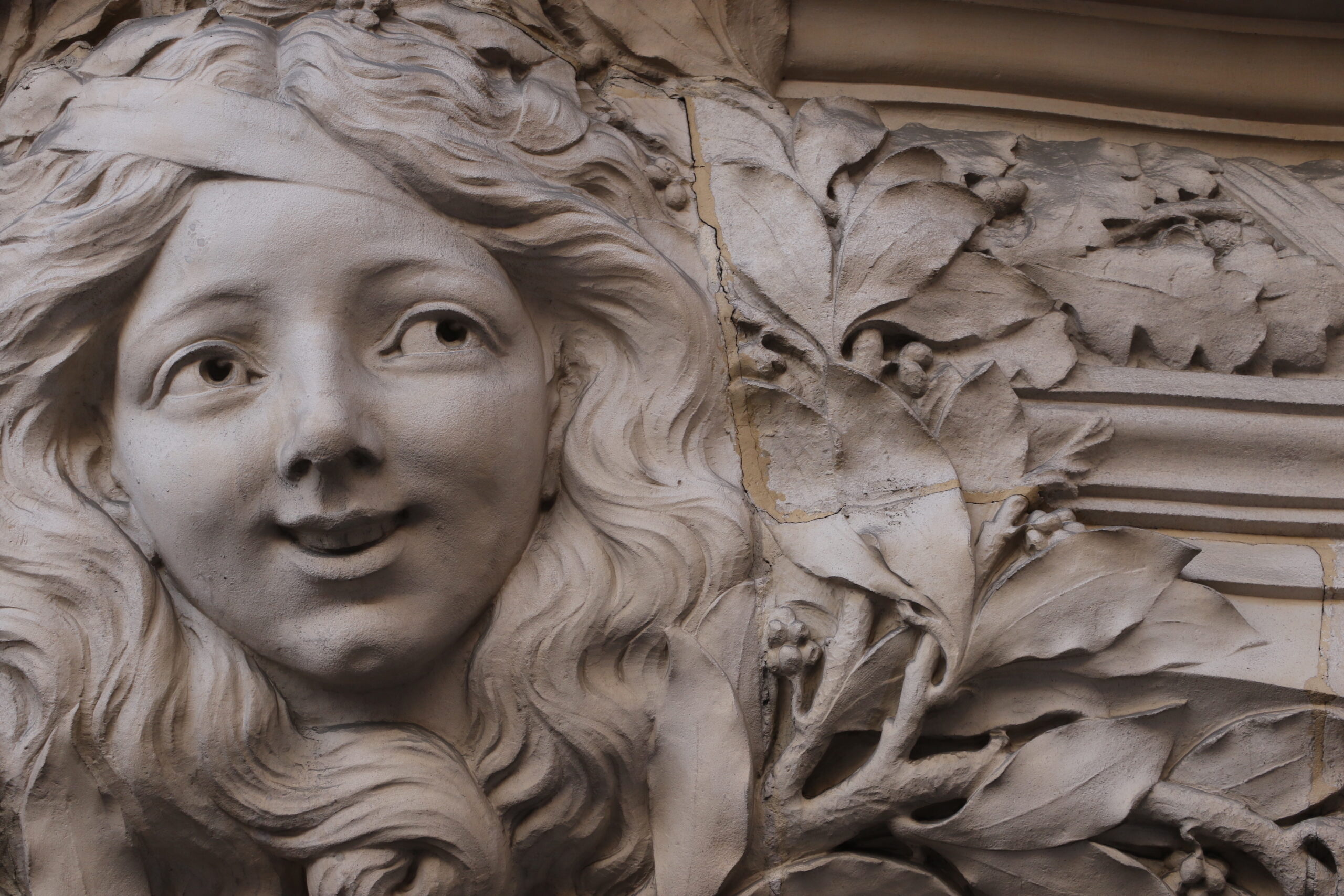 Urban Artistry: Sculpted Woman’s Head Enhancing a Parisian Building Facade Urban Artistry: Sculpted Woman’s Head Enhancing a Parisian Building Facade